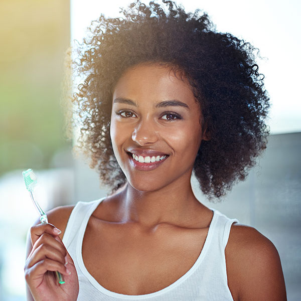 Woman happily smiling brushing teeth