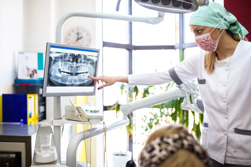Dental professional reviewing wisdom teeth X‑ray with patient during consultation in Mokena, IL